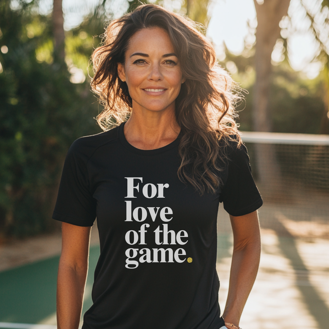 Woman wearing a black pickleball t-shirt that says for love of the game