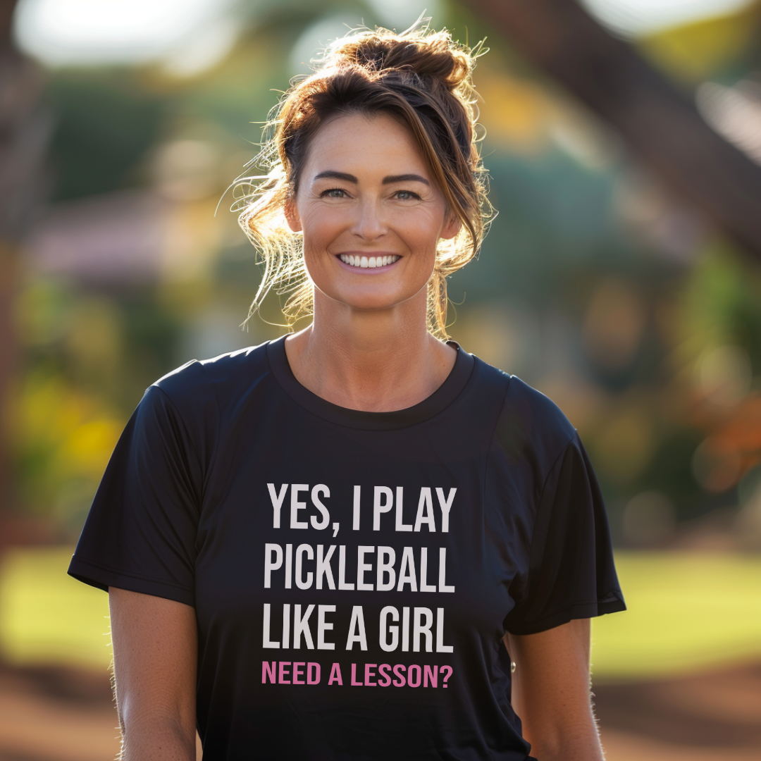 Woman wearing a black pickleball t-shirt that says yes I play pickleball like a girl need a lesson