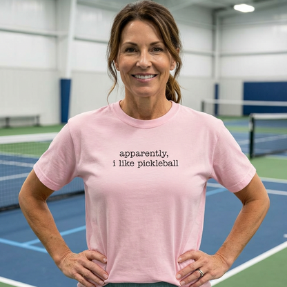 Woman wearing a pink apparently, I like pickleball t-shirt on an indoor pickleball court