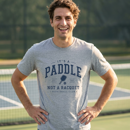 Man wearing a gray pickleball t-shirt on a pickleball court
